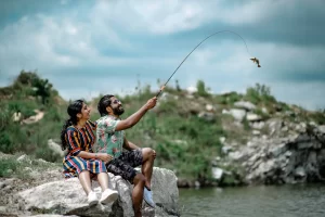 Pre-Wedding Photoshoot of couple setting on stone, wearing green shirt and blue top
