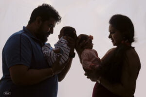 A silhouette of a man and woman holding their baby.