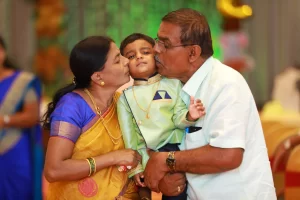indian couple kissing a child