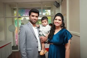 A man and woman holding a baby in a room.