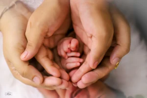 A mother's hands holding a newborn baby.