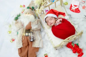 A baby is laying in a crib with a santa claus doll.