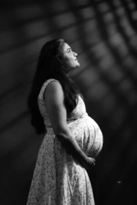 A pregnant woman in a black and white photo.