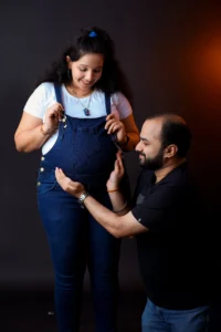 A man and woman are posing for a maternity photoshoot.
